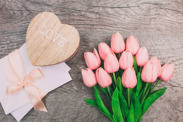 Strauß Rosa Tulpen Holzherz Und Weißer Umschlag Auf Hölzernem Hintergrund — Stockfoto