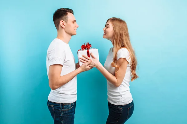 爱的夫妻男人和女人 站在礼品盒 幸福的一对在浅蓝色的背景 情人节 — 图库照片