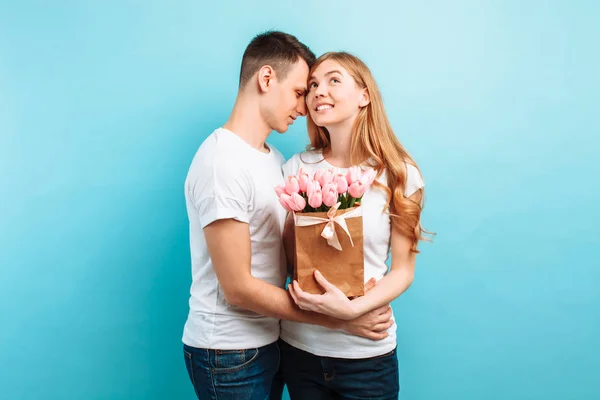 Attractive Man Gives His Girlfriend Bouquet Pink Tulips Blue Background — Stock Photo, Image