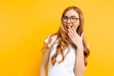 Kız utanç duygu gösterir, güzel bir kadının elini ve geniş, sarı bir arka plan üzerinde gülümseyen arkasında şaşırır