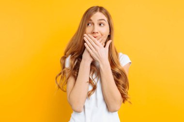 kız ağzını sessizlik kavramı, sarı bir arka plan şok kadın her iki el ile kaplı