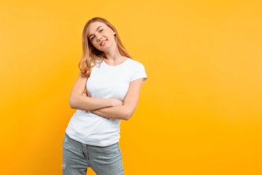 Beyaz tişört, dalgın bir kız portresi, rüya gibi kız, sarı bir arka plan üzerinde görünüyor