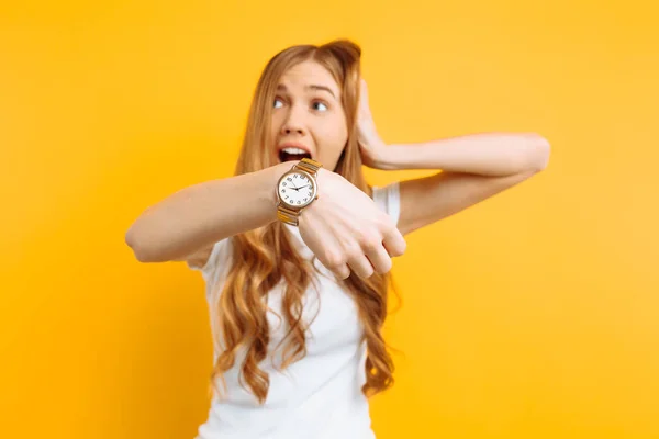 Piękna Dziewczyna Patrząc Zegarek Ręka Wskazuje Zegarek Żółtym Tle Pojęcie — Zdjęcie stockowe
