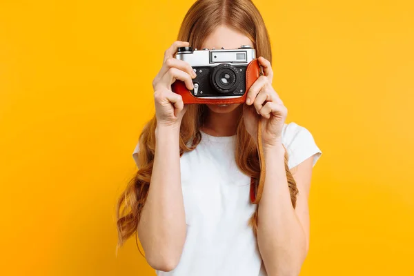 Mooi Meisje Met Een Camera Haar Handen Een Gele Achtergrond — Stockfoto