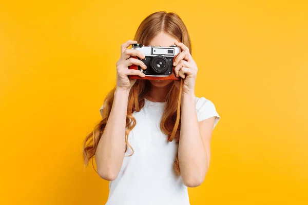 Mooi Meisje Met Een Camera Haar Handen Een Gele Achtergrond — Stockfoto