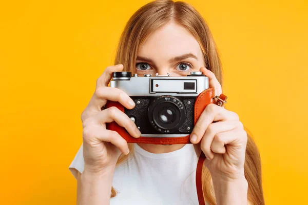 Mooi Meisje Met Een Camera Haar Handen Een Gele Achtergrond — Stockfoto