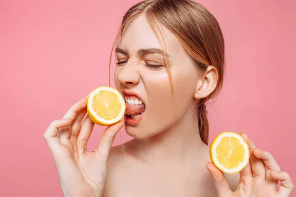 Bir neşeli kadınsı kız, doğal açık cilt, pembe bir arka plan üzerinde izole iki limon dilimleri ile kız portresi. Cilt bakım kavramı, doğal güzellik
