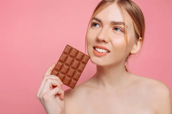 Mooie vrolijke jonge vrouw houden een staaf-van-zwarte chocolade — Stockfoto