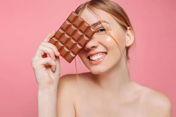 Jonge vrouw met schone huid een zwarte balk van chocolade in bedrijf — Stockfoto