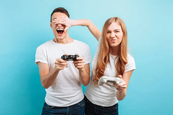 Excited young couple, a guy and a girl, with joysticks in their — Stock Photo, Image