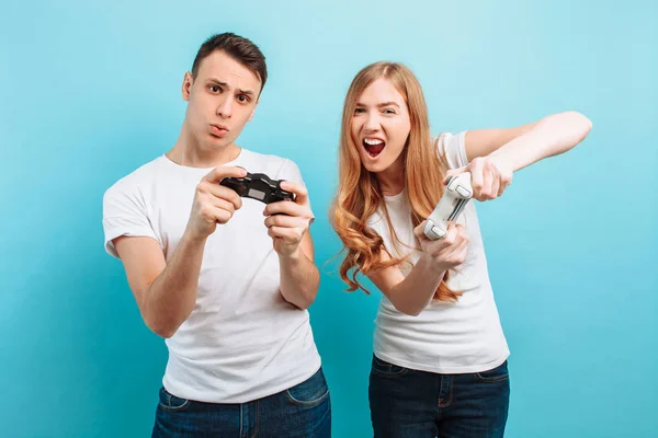 Excited young couple, a guy and a girl, with joysticks in their — Stock Photo, Image