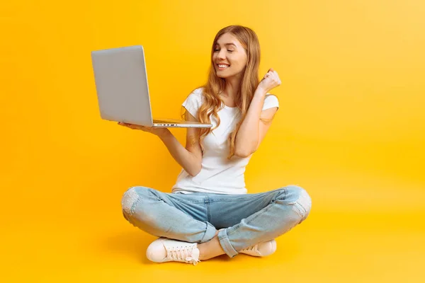 Joven mujer feliz está sentado usando el ordenador portátil y celebrando vencedor —  Fotos de Stock