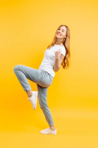 Volledige lengte, enthousiaste meisje, vieren van succes op een geel — Stockfoto