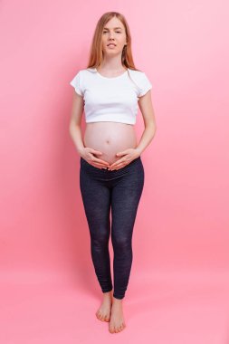 Atletik hamile kız gücü bir jest gösterir