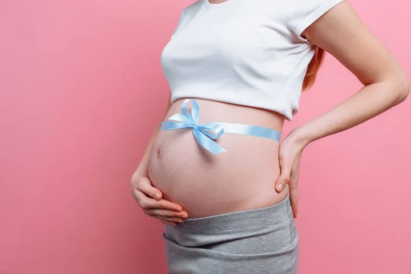 An image of a pregnant woman with a blue ribbon on her belly — Stock Photo, Image