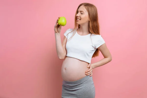 Elinde yeşil elma olan hamile bir kadın. Gebelik kavramı, annelik, doğru beslenme — Stok fotoğraf