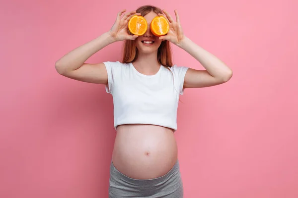 Portakal meyveile güzel hamile kadın — Stok fotoğraf