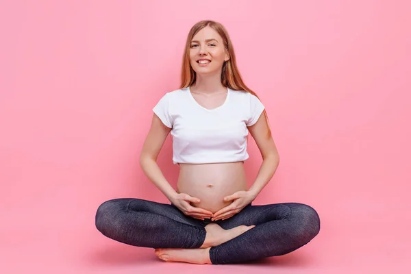 Jeune fille enceinte étreignant son ventre avec ses mains — Photo