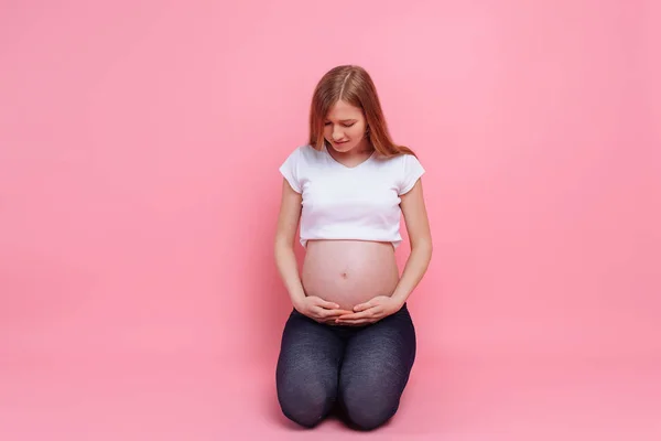 Νεαρή έγκυος που αγκαλιάζει την κοιλιά της με τα χέρια της — Φωτογραφία Αρχείου