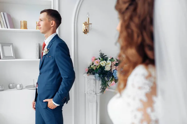 Beautiful bride in white dress and groom in suit, posing in white Studio interior, wedding — Stock Photo, Image