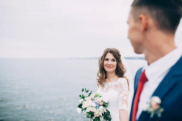 Свадебная пара на море, влюбленные на пирсе — стоковое фото