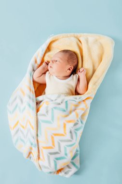 yeni doğmuş bir bebek, sıcak bir battaniye içinde gülümseyen güzel bir bebek