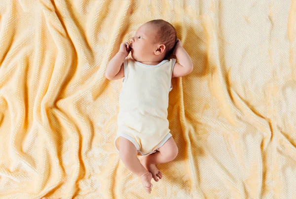 Um bebê recém-nascido, um lindo bebê que sorri, em um cobertor quente — Fotografia de Stock