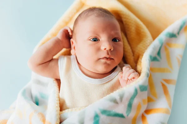 Um bebê recém-nascido, um lindo bebê que sorri, em um cobertor quente — Fotografia de Stock