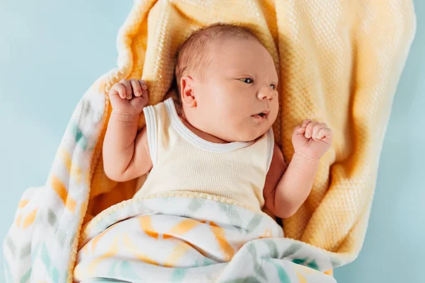 Um bebê recém-nascido, um lindo bebê que sorri, em um cobertor quente — Fotografia de Stock