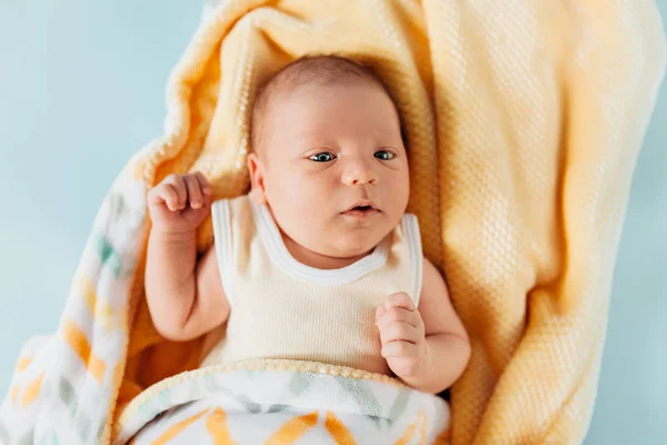 Ένα νεογέννητο μωρό, ένα όμορφο μωρό που χαμογελά, σε μια ζεστή κουβέρτα — Φωτογραφία Αρχείου