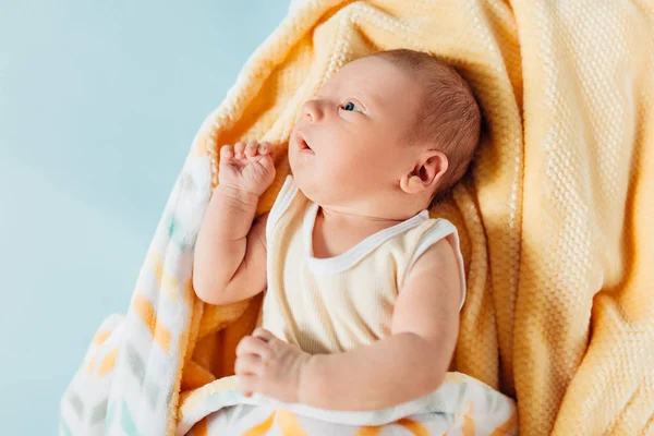 Um bebê recém-nascido, um lindo bebê que sorri, em um cobertor quente — Fotografia de Stock