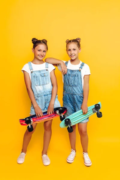 Dos adolescentes, niños elegantes posando con patinetas en su — Foto de Stock