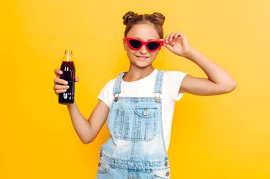 Mutlu genç kız ferahlatıcı ile sarı bir arka plan üzerinde dinlenme