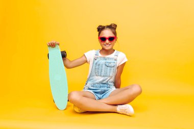 kaykay ile oturan genç, sunglas poz şık kız