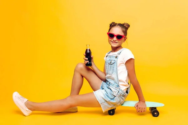 Adolescente felice, ragazza in occhiali da sole con uno skateboard e un refre — Foto Stock