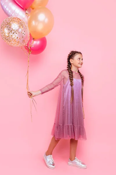 Feliz y hermosa chica adolescente sosteniendo un montón de globo de colores — Foto de Stock