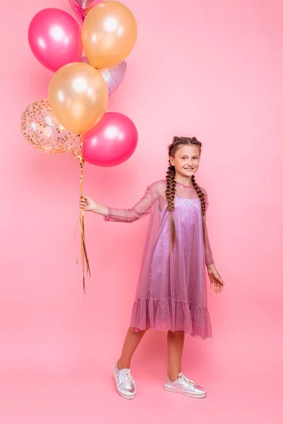 Feliz y hermosa chica adolescente sosteniendo un montón de globo de colores — Foto de Stock