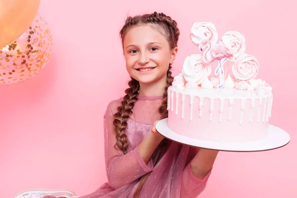 Una adolescente con globos sostiene un pastel en sus manos, en un alfiler — Foto de Stock