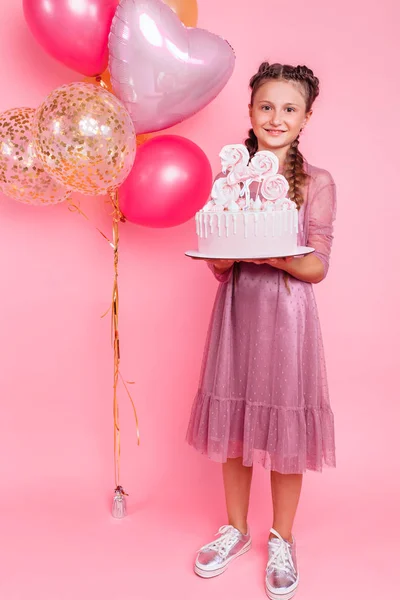 Mladá dívka s balónky má v rukou dort, na špendlíku — Stock fotografie