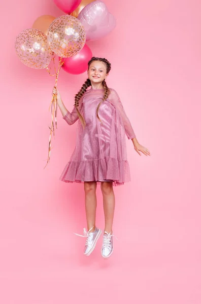 Feliz adolescente saltando alto con globos aislados en rosa b — Foto de Stock