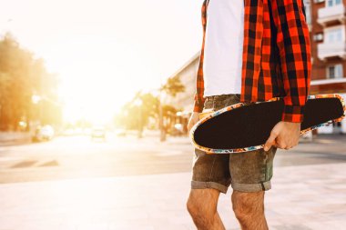 gün batımında kaykay ile sakallı adam.