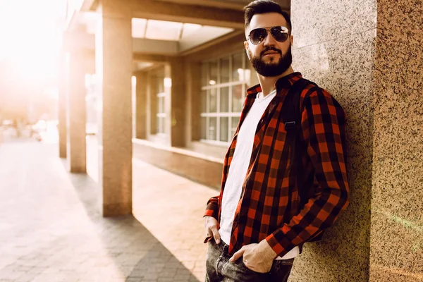Kablosuz kulaklık sakallı şık adam şehirde bir binanın yakınında poz