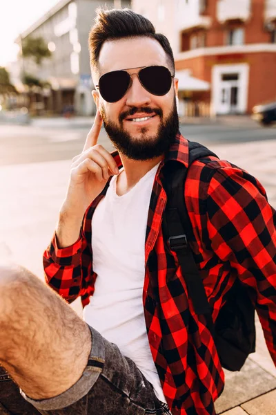 Стильний хлопець з бородою в бездротових навушниках говорить — стокове фото