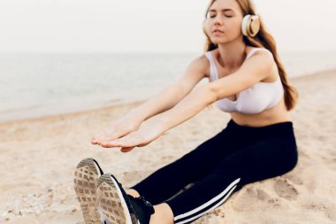 Genç sportif kız açık havada germe egzersizleri yapıyor, ve liste