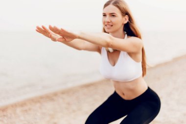 Genç güzel atletik kız açık havada spor yapıyor, denizde