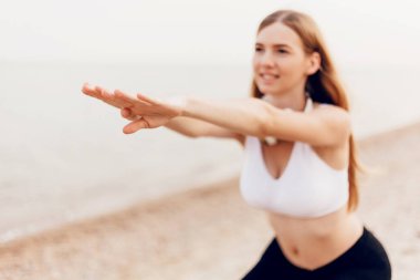 Genç güzel atletik kız açık havada spor yapıyor, denizde