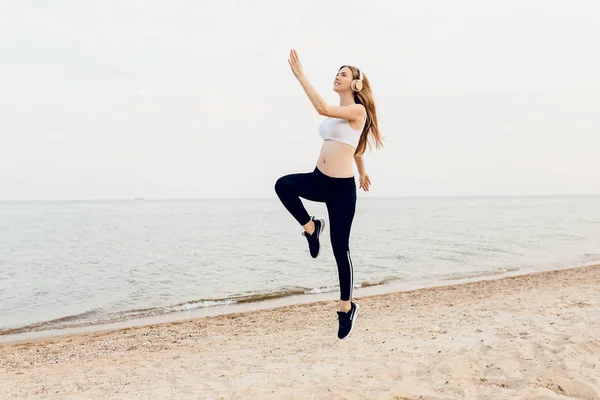 Jonge mooie atletische meisje doet sporten, doen springen, elkaar overtreffen — Stockfoto