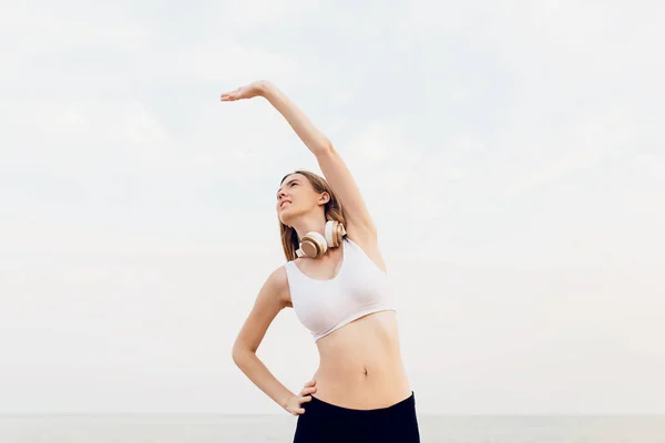 Junge starke Fitness-Frau morgens am Strand — Stockfoto