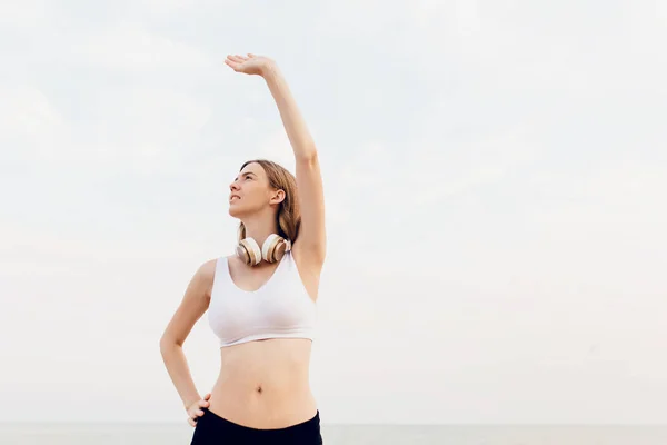 Jonge sterke fitness vrouw buitenshuis op het strand in de ochtend — Stockfoto