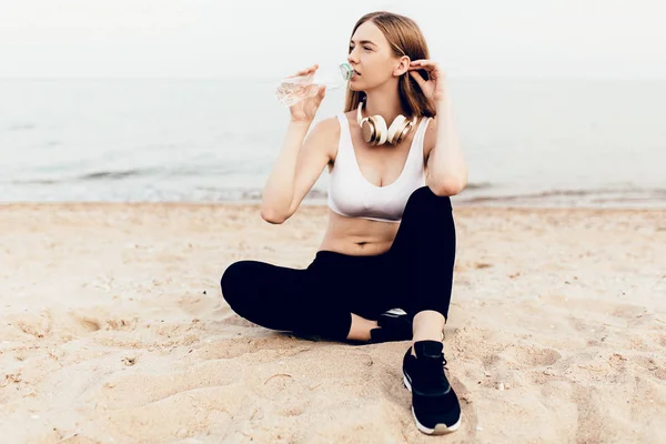 Nahaufnahme eines müden jungen Mädchens, das Wasser aus einer Flasche nach dem anderen trinkt — Stockfoto